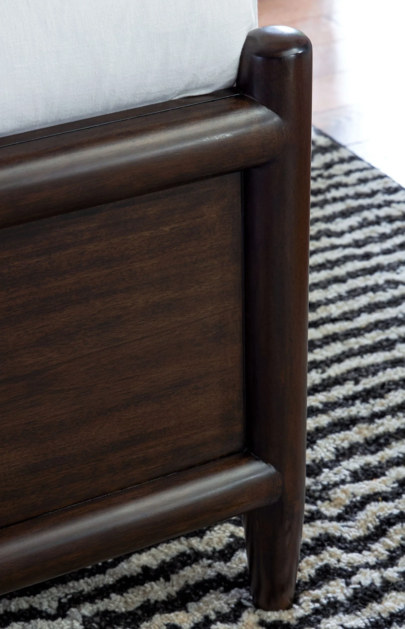 Panel Bed — Its simple yet chic design features rounded wooden frames and a rich merlot finish that exude a metropolitan vibe